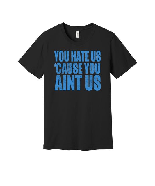 You Hate Us Because You Ain't Us graphic on a black Bella+Canvas 3001 tee